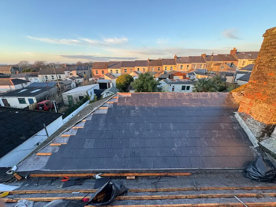 New slates going on over fresh battens on a terraced house roof